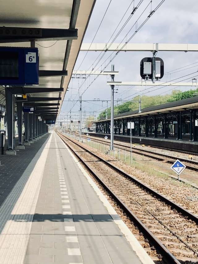 A train station with empty tracks and a sign.