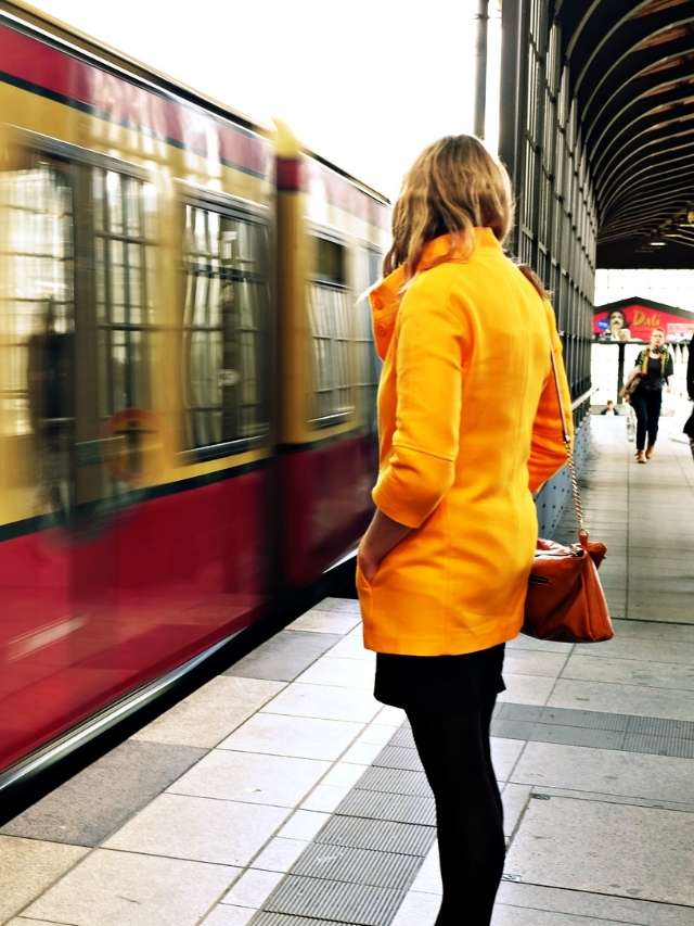 A woman is waiting for a train.