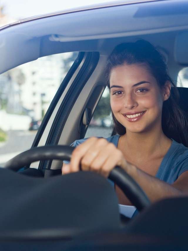 A young woman driving a car.