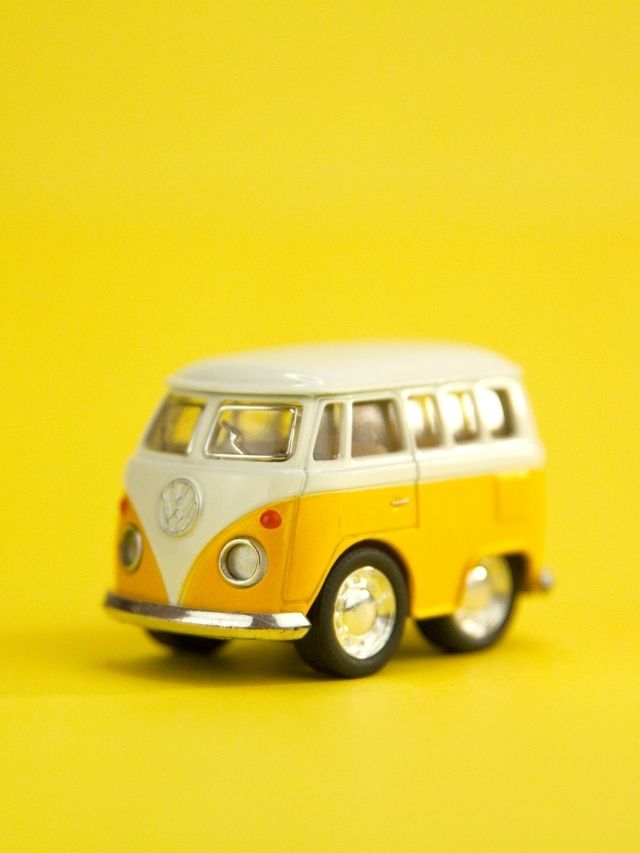 A toy vw bus on a yellow background.
