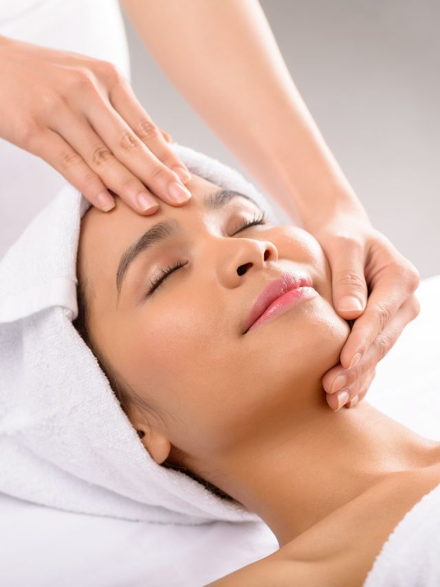 A woman receiving a facial massage in a spa during a photo facial treatment.
