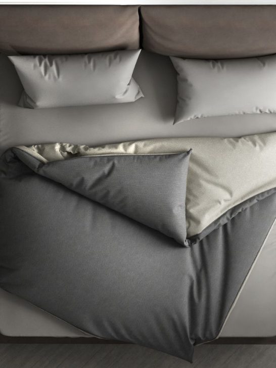 An image of a bed with grey and white pillows.