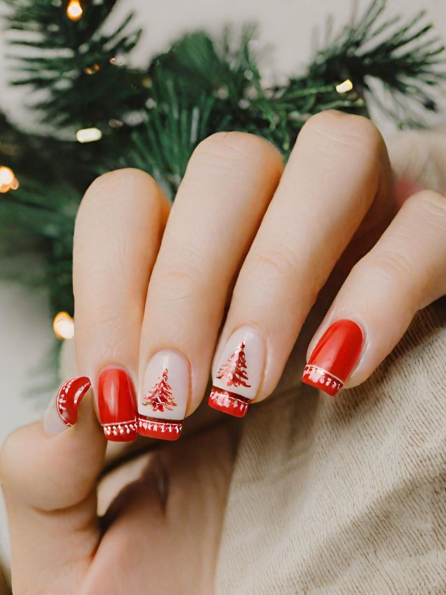 A woman with red and white nails holding a christmas tree.