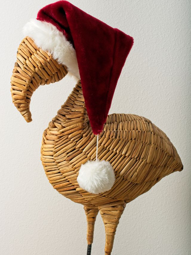 A wicker flamingo wearing a santa hat.