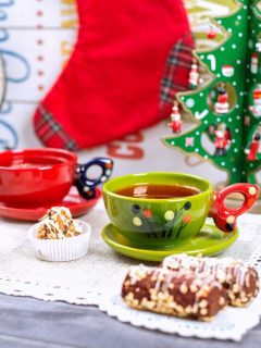 Christmas tea with cookies and stockings on a wooden table.