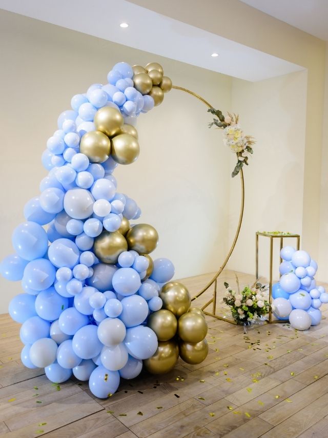 A balloon arch decorated with blue and gold balloons.