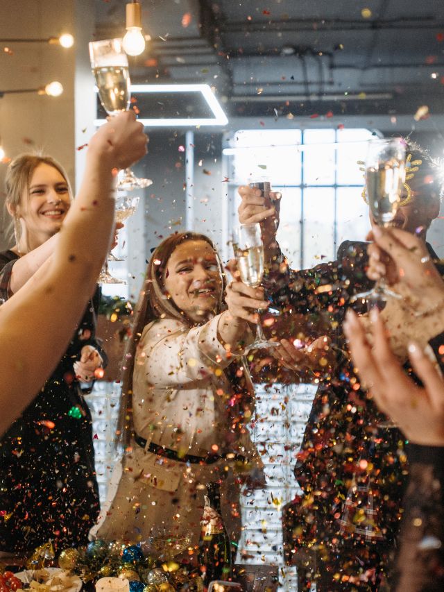 A group of people toasting with confetti at a party.
