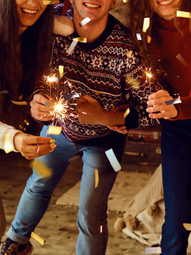A group of friends holding sparklers at a party.