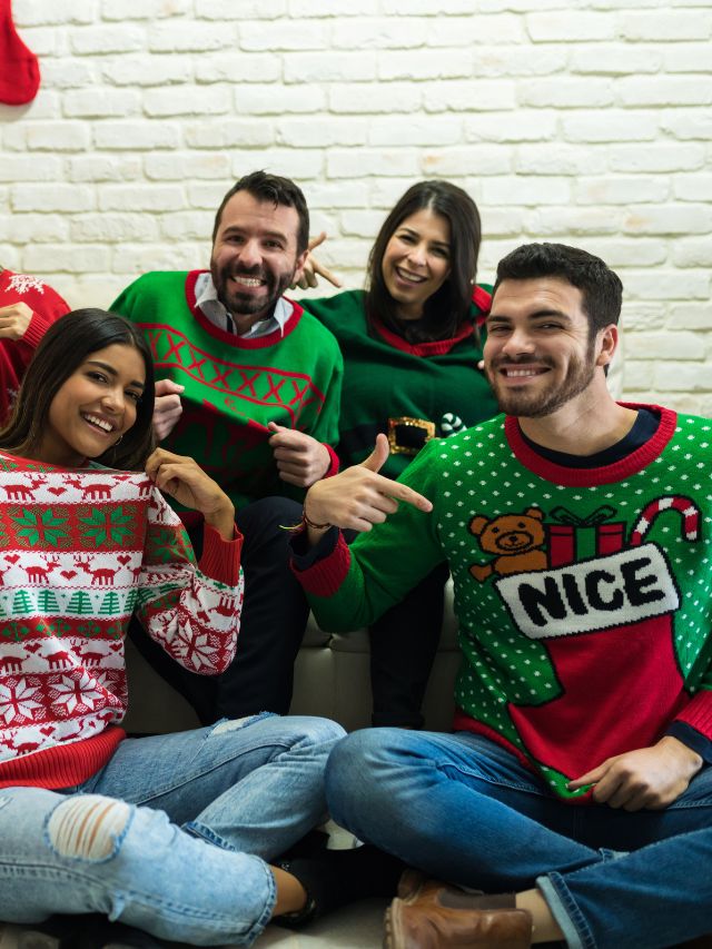 A group of people in ugly christmas sweaters posing for a photo.