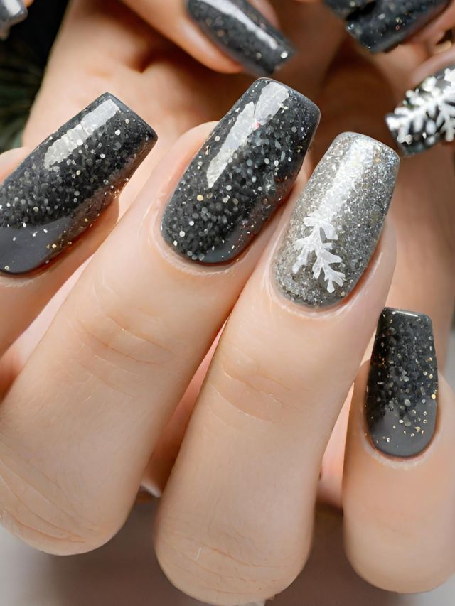 A woman's nails with glitter and snowflakes on them.