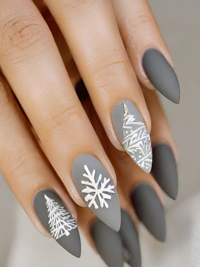 A woman's nails with snowflake designs on them.