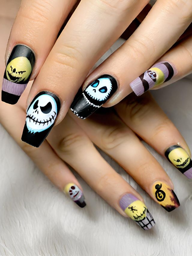 A woman's nails are decorated with jack skellington and jack o lantern.