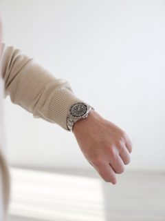 A man's wrist with a watch on it.