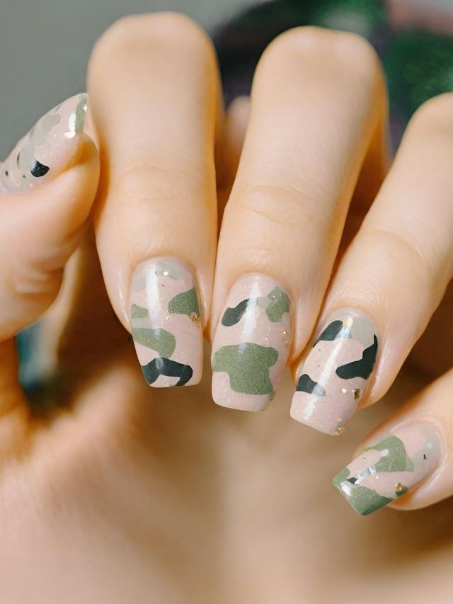 A woman's nails with camouflage designs on them.