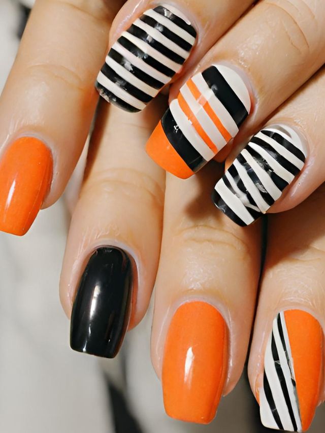 A woman with orange and black stripes on her nails.