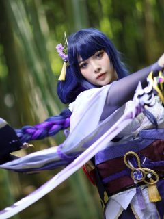 A female cosplayer in a blue costume holding a sword.
