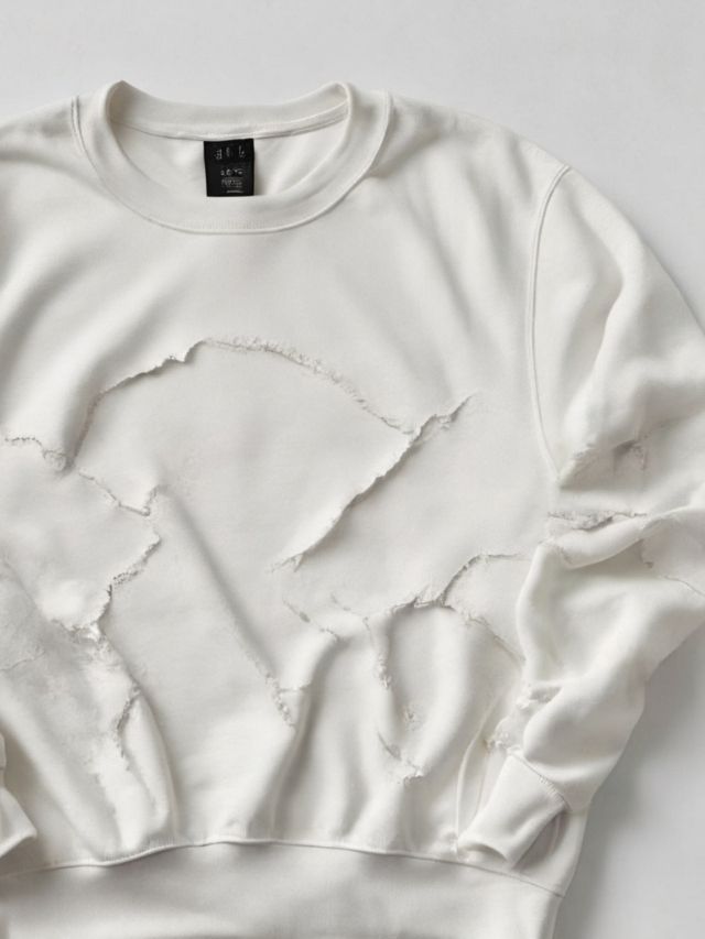 A white sweatshirt with holes on it.