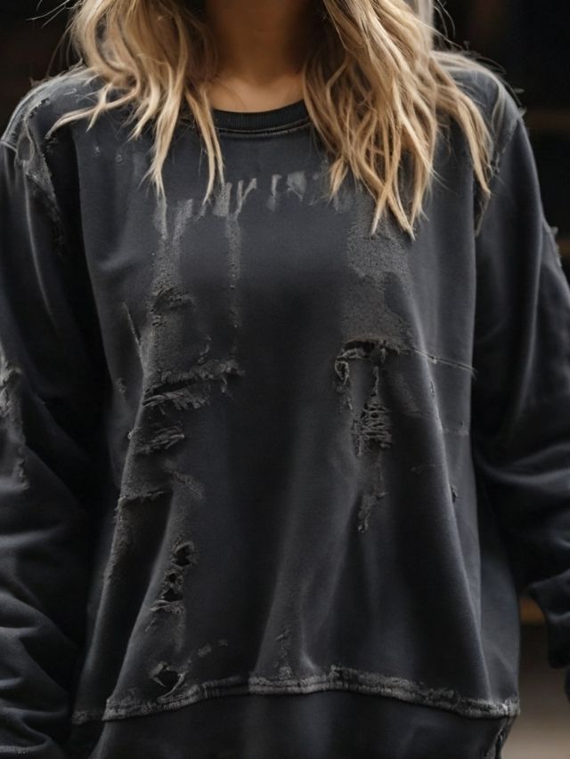 A woman wearing a black distressed sweatshirt.
