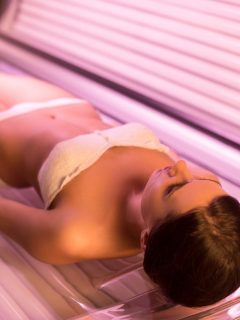 A woman laying on a tanning bed.