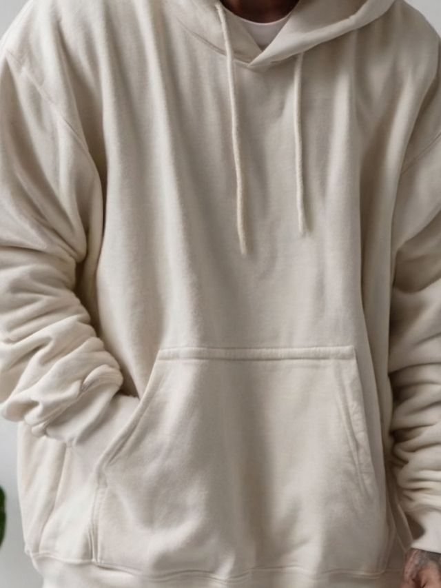 A man wearing a cream hoodie.