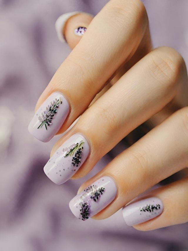 A woman's nails with lavender flowers on them.