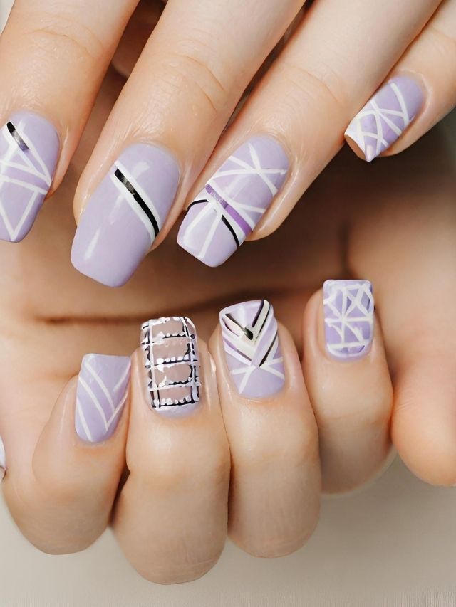 A woman's hand with purple and white nail designs.