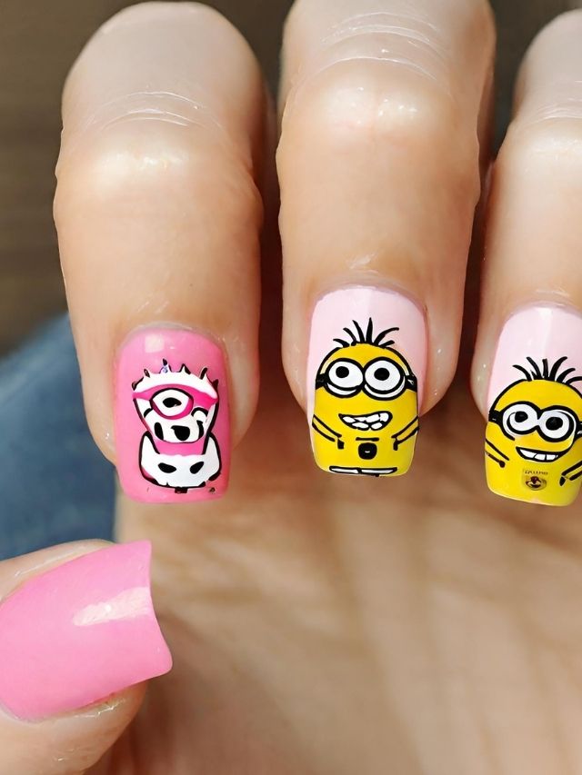 A girl holding up a pink and yellow nail with minions on it.