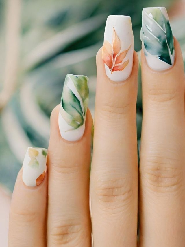 A woman's nails with leaves painted on them.