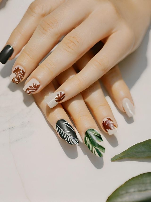 A woman's nails with leaves and leaves on them.