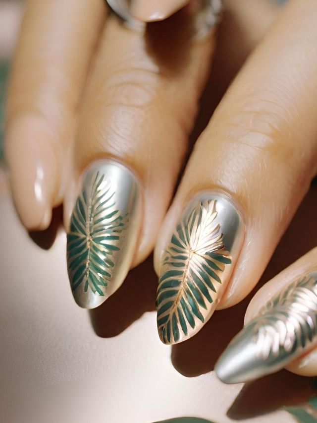 A woman's nails with gold and silver leaf designs.