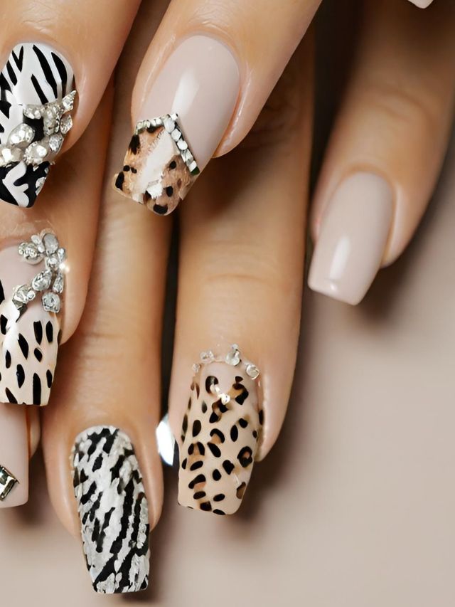 A woman's nails are decorated with leopard print and diamonds.