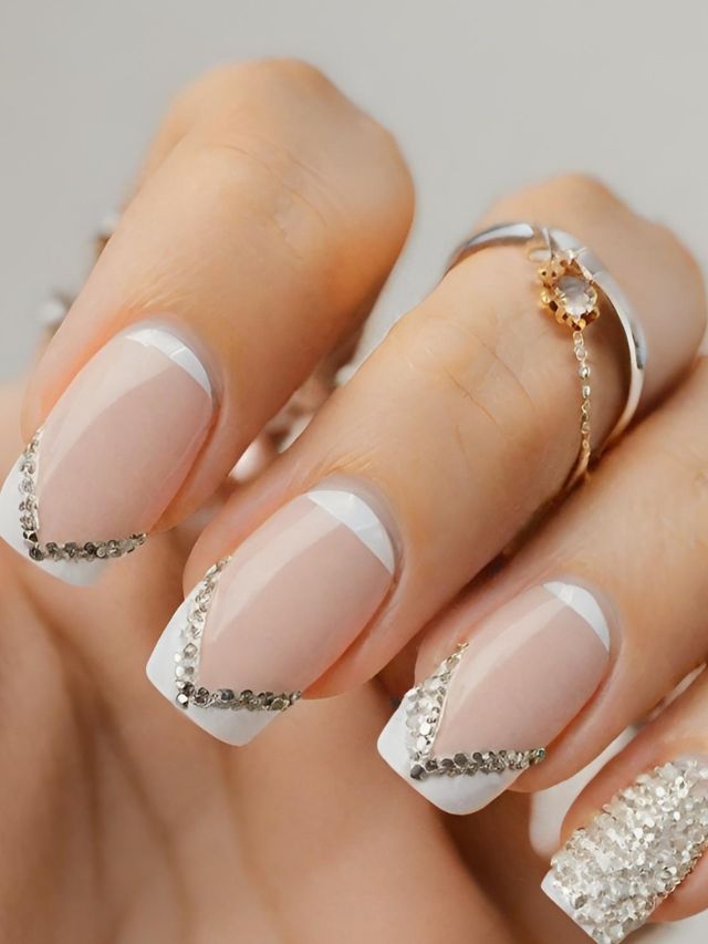 A woman's hand with white and silver nails.