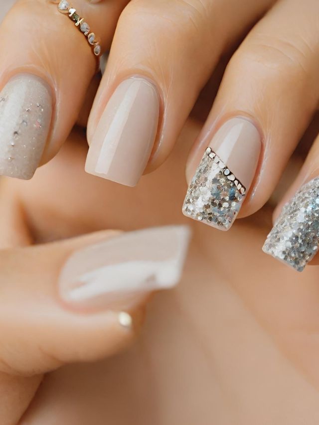 A woman's hand with silver and beige nails.