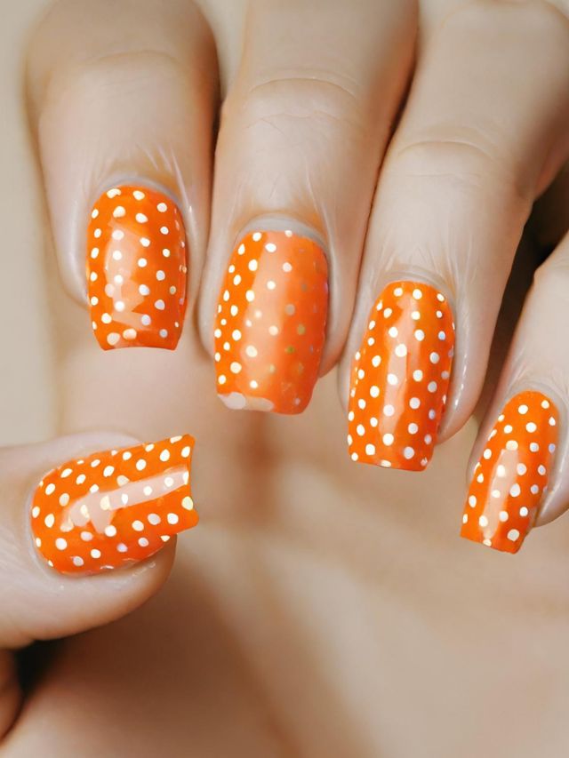Orange and white polka dot nail art.