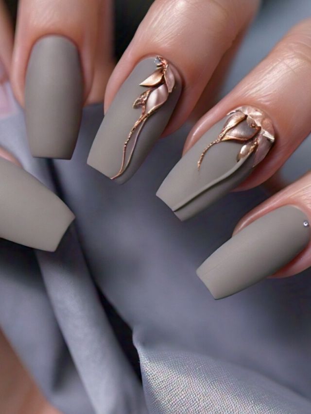 A woman is showcasing a luxurious gray nail adorned with exquisite rose designs, illustrating creative and captivating nail art ideas.