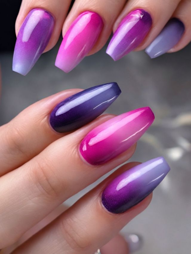 A woman's hand displaying purple and pink ombre nails featuring a touch of blue in the design.