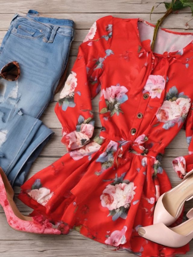 A red floral dress, jeans and shoes on a wooden floor.