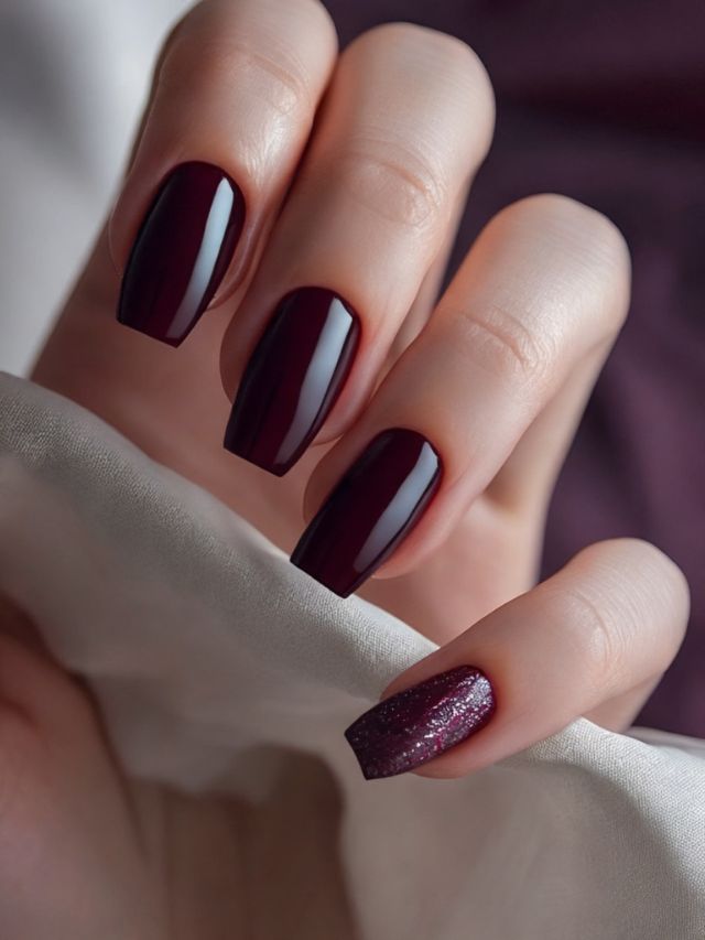 A hand with elegantly long and vibrant red nails.