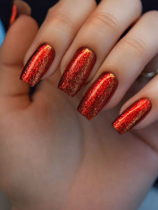 A hand showcasing stunning fall red nail designs with long nails.