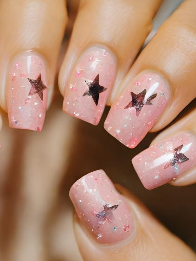 A woman's pink nails adorned with stars, perfect for Valentines dip nail ideas.