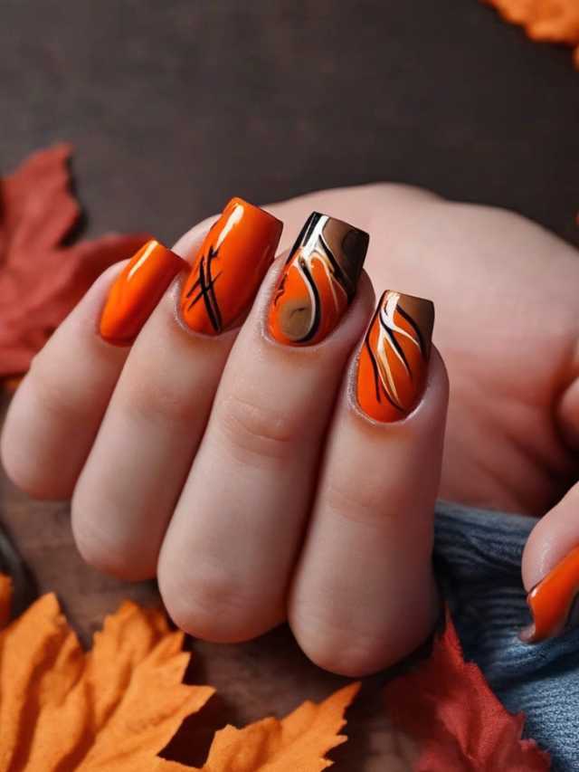 A woman's hand with orange and black nail designs.