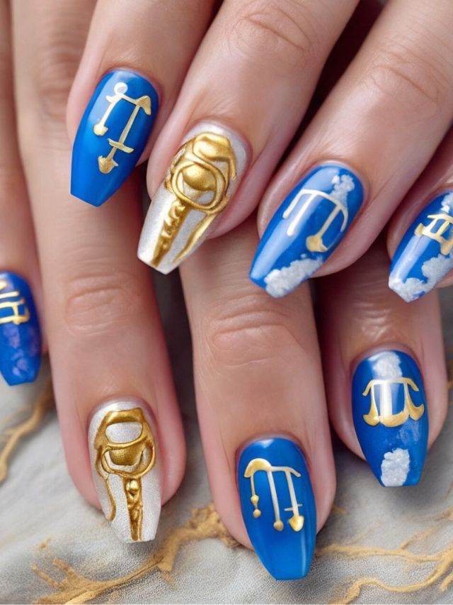 A woman with blue and gold nails with zodiac signs on them.