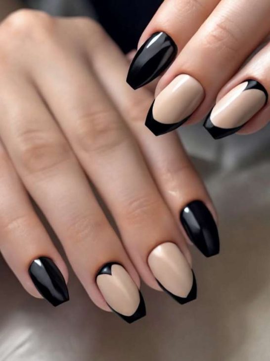A woman's hand with black and beige nails.