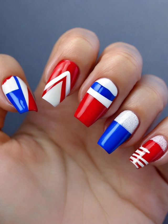 A woman's nails are decorated with red, white, and blue designs inspired by the Buffalo Bills.