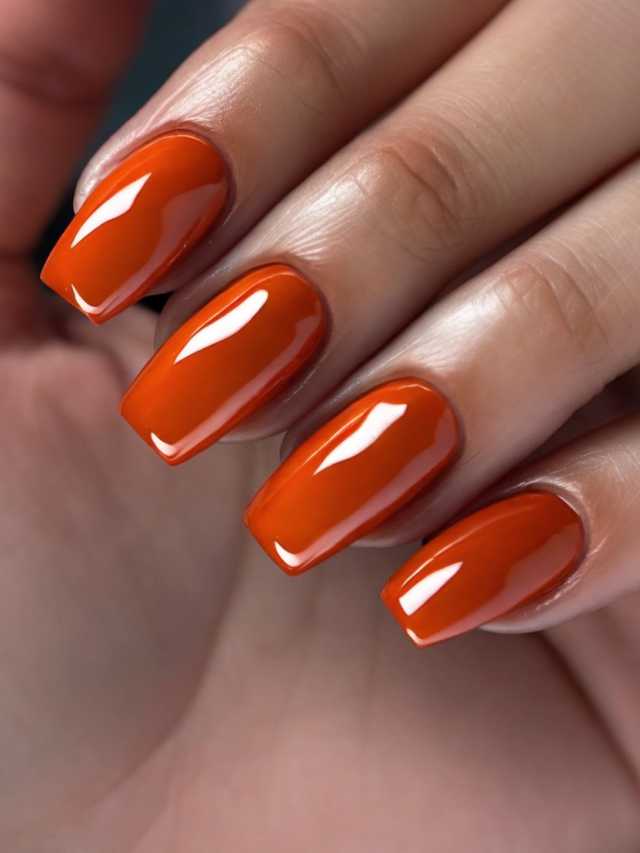 A woman's hand with orange nail polish.
