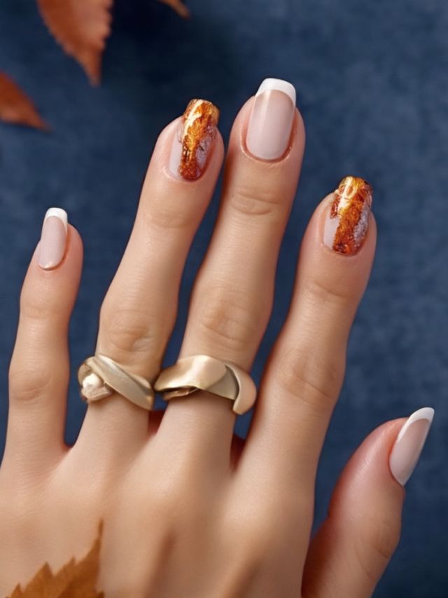 A woman's hand with autumn nails and rings.