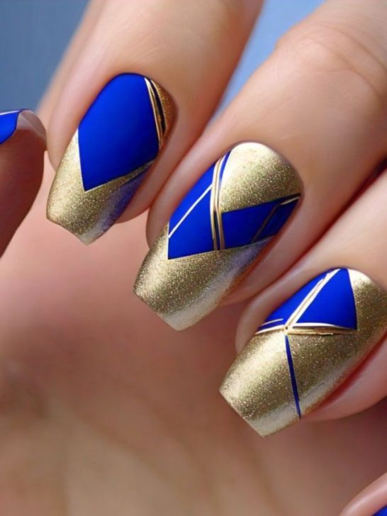 A woman's nails with blue and gold geometric designs.