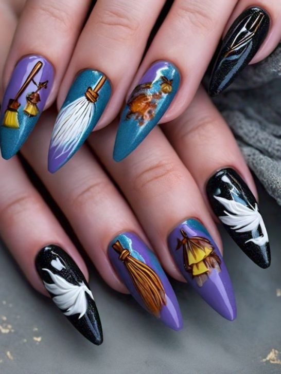 A woman's nails are decorated with witches and brooms.