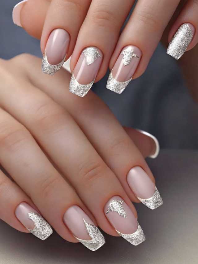 A woman's nails with white and silver designs.