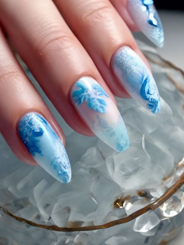 A woman's nails are decorated with blue and white snowflakes.